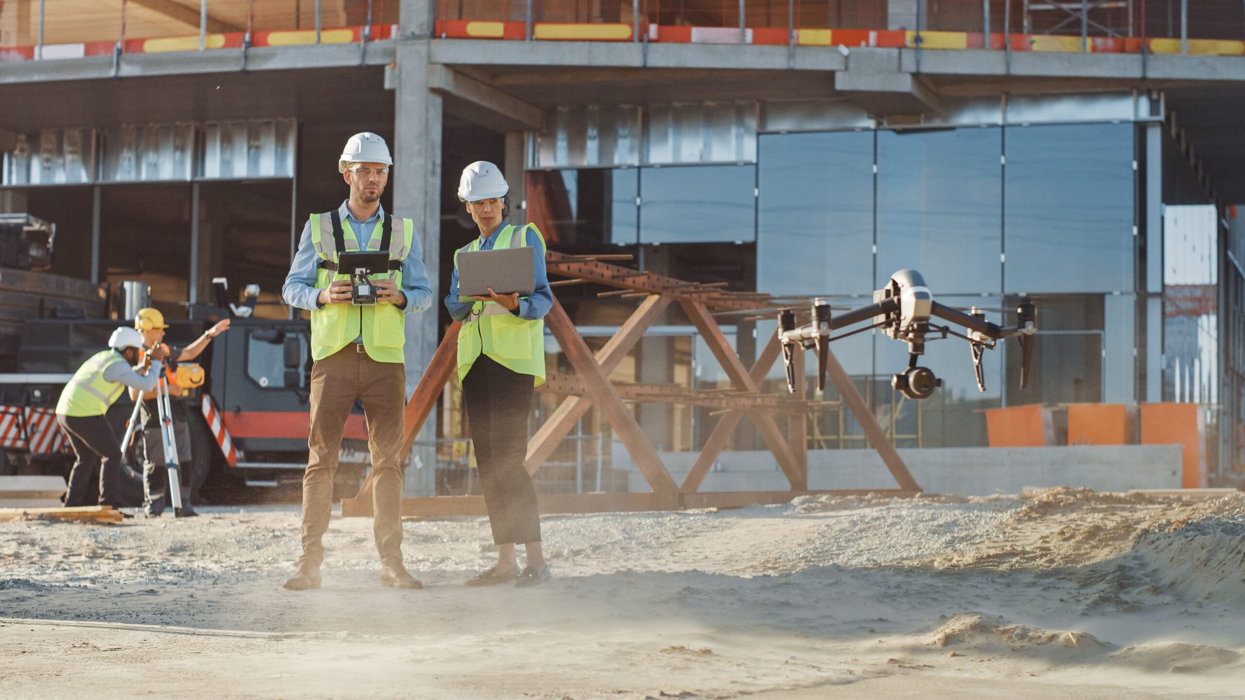 Two Specialists Controlling Drone on a Construction Site Architectural Engineer and Safety Engineering Inspector Fly Drone on Commercial Building Construction Site Controlling Design and Quality