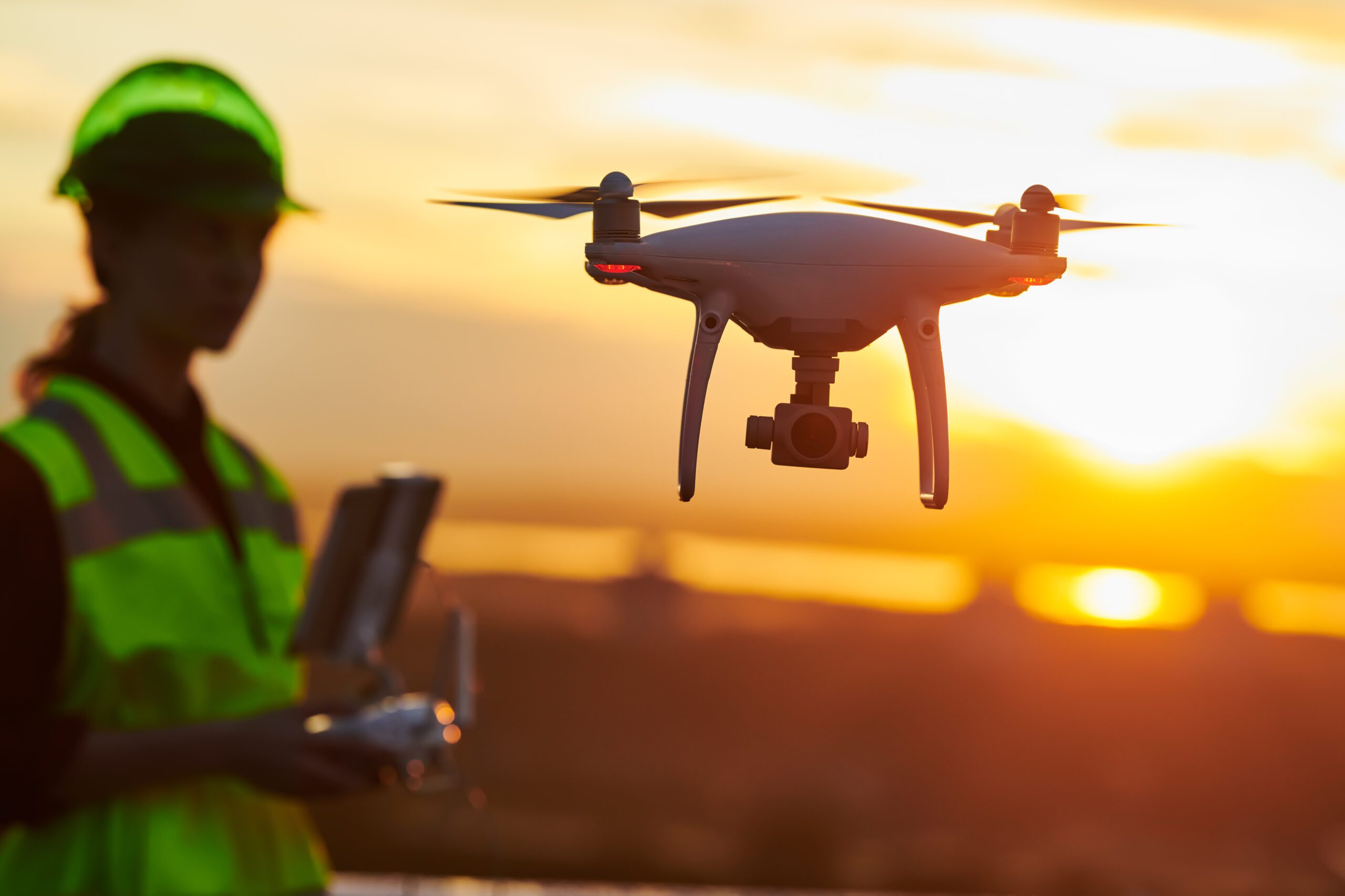 Drone inspection Operator inspecting construction building site flying with drone sunset